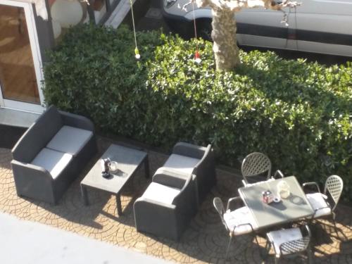 a patio with couches and chairs and a table at Hotel La Vigna in Moneglia