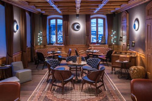 a restaurant with tables and chairs and windows at Riffelalp Resort 2222m Ski-in & Ski-out in Zermatt