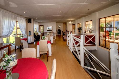 comedor con mesa roja y sillas en 15 On Penguin Guesthouse, en Simonʼs Town
