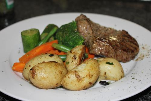 a plate of food with meat potatoes and vegetables at Fin and Feather Guest Lodge in Boksburg