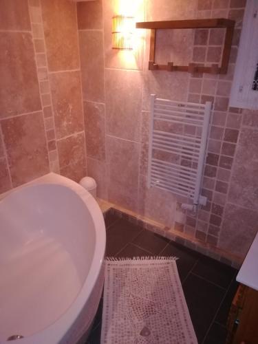 y baño con aseo blanco y bañera. en Maisonnette de Villiers en Saint-Fargeau-Ponthierry