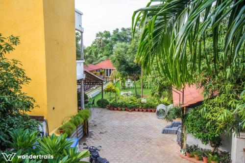 a courtyard of a building with plants and trees at Poppys Olive de' villa in Auroville