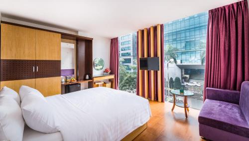 um quarto com uma cama e uma grande janela em OYO 1162 Tu Sakura Hotel em Hanói