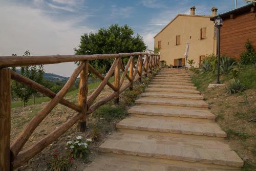 a wooden staircase leading to a house with a fence at AGRITURISMO Ca' Maggio in Sassofeltrio