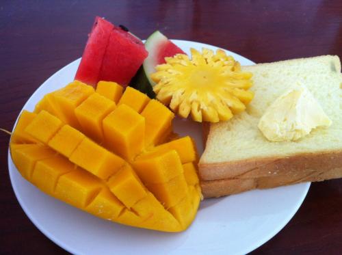 a plate of food with bread and fruit on it at Chamkachuk Home in Siem Reap