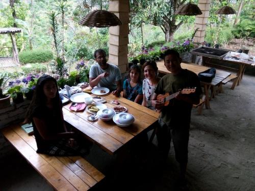 a group of people sitting around a wooden table at Tathagata Farm in Darjeeling