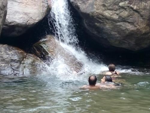 a group of people in the water near a waterfall at Tathagata Farm in Darjeeling