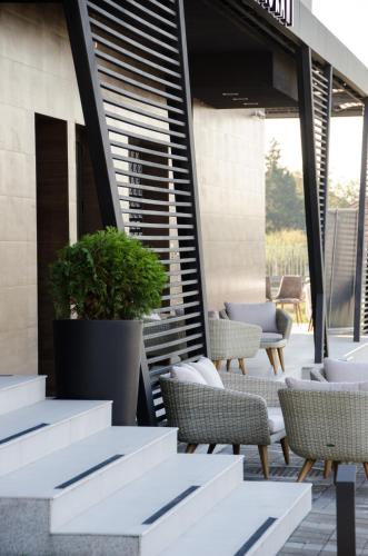 a patio with wicker chairs and tables on a building at Hotel Ideo Lux in Niš