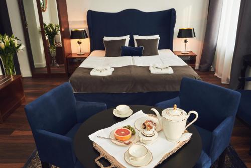 een hotelkamer met een bed en een dienblad met eten op een tafel bij Shalom Kazimierz in Krakau