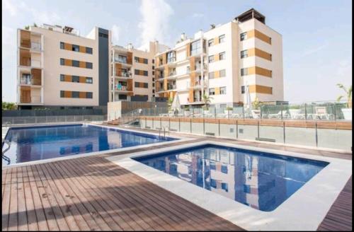 a swimming pool in front of a apartment building at Relax, sol y playa in El Campello