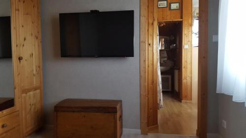 sala de estar con TV de pantalla plana en la pared en Ferienhaus Weiser, en Cuxhaven