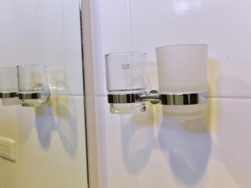 a bathroom with two wine glasses on a wall at Anahaw Apartments Whitebeach in Boracay