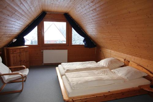 a bedroom with two beds in a wooden cabin at Ferienhaus 3 Köhr-Eickhoff in Lembruch
