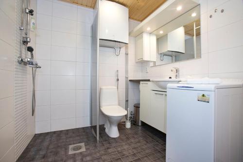 La salle de bains blanche est pourvue de toilettes et d'un lavabo. dans l'établissement RovaVisit Apartments Paroni, à Rovaniemi