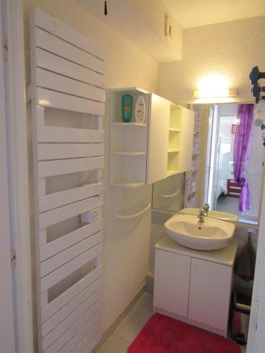 La salle de bains blanche est pourvue d'un lavabo. dans l'établissement Les rives du lac, au Grau-du-Roi