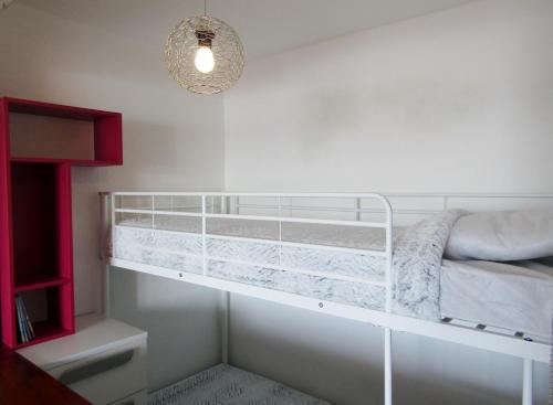 Ce lit superposé blanc se trouve dans une chambre blanche. dans l'établissement Les rives du lac, au Grau-du-Roi