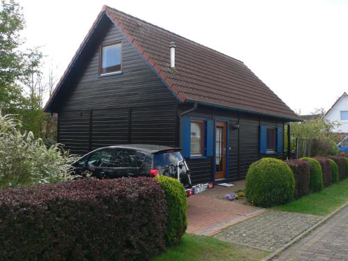 a black house with a car parked in front of it at Ferienhaus 3 Köhr-Eickhoff in Lembruch