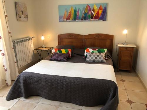 ein Schlafzimmer mit einem großen Bett mit Kissen darauf in der Unterkunft Jac'Soul Restaurant & Chambres d'hotes in Sablet