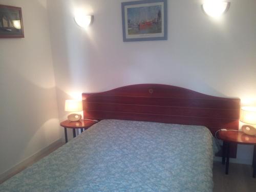 - une chambre avec un lit et deux lumières sur deux tables dans l'établissement Sémaphore, à Les Sables-dʼOlonne