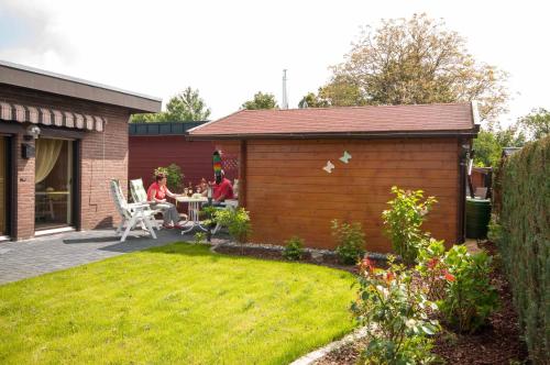 a group of people sitting at a table in a garden at Haus Seestern in Kalkar