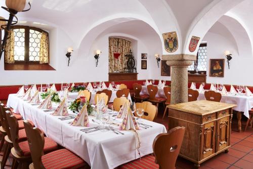 a row of tables in a restaurant with white tablecloths at Hotel Gäubodenhof in Straubing
