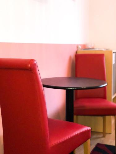 two red chairs and a table and a table and chairs at Smještaj Natalija in Osijek