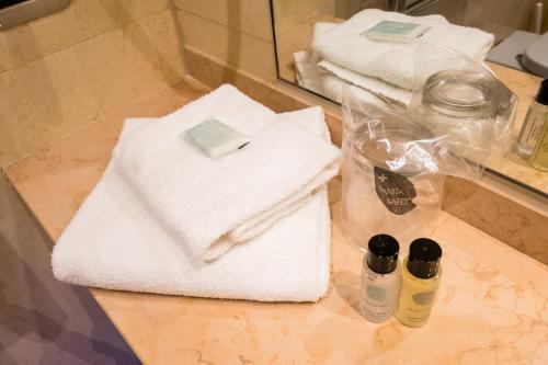 a pile of towels on a counter in a bathroom at Palace Hotel & SPA La CONCHIGLIA D' ORO in Vicenza