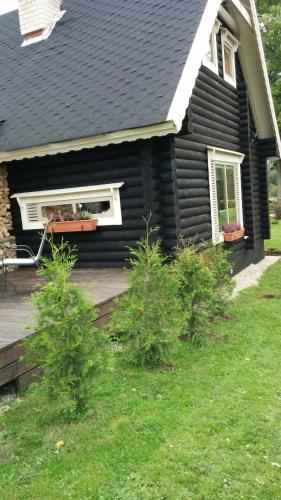 a black house with a deck and a window at Safari House in Otepää