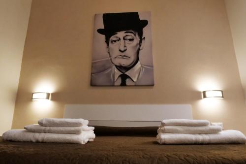 a painting of a man in a top hat on a wall with towels at B&B Il Campanile in Naples