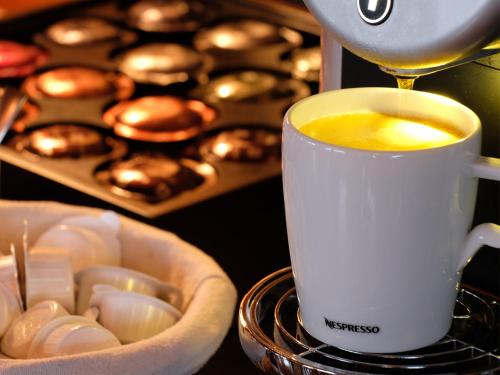 une cafetière qui prépare une tasse de café à côté de muffins dans l'établissement Esprit Montagne, à La Chapelle-dʼAbondance