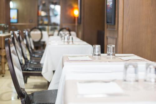 a row of tables in a restaurant with white table cloth at Hôtel Les Voyageurs in Bastia