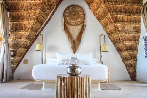 
a room with a large bed and a large window at Hotel Villas Flamingos in Holbox Island
