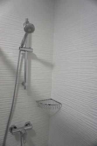 La salle de bains est pourvue d'une douche avec un pommeau de douche. dans l'établissement Black & White Las Canteras, à Las Palmas de Gran Canaria