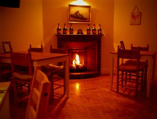 a living room with a fireplace and a table and chairs at The Moorhead Bed & Breakfast in Wem