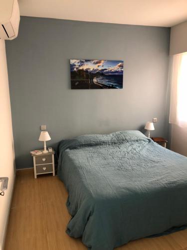 une chambre avec un lit et un tableau au mur dans l'établissement Bright apartment with a garden and a wonderfull sea view, au Trayas