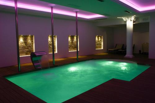 a swimming pool in a room with purple and green lighting at Hotel Vittoria in Pesaro