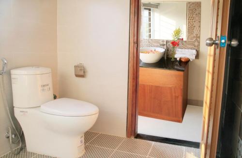 a bathroom with a white toilet and a window at Melody Boutique Villa Hoi An in Hoi An