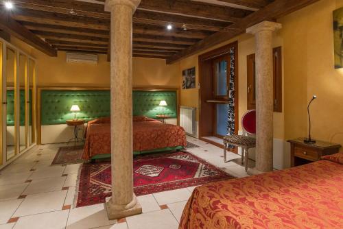 a bedroom with two beds and a large column at Sant'Angelo - Fenice Apartments in Venice in Venice