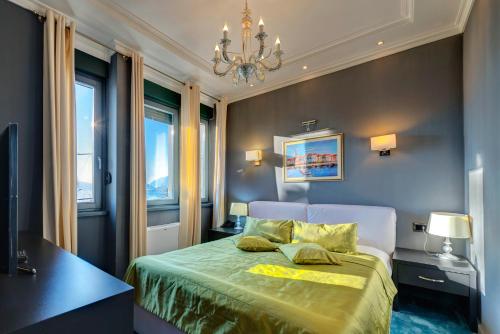 sypialnia z łóżkiem i żyrandolem w obiekcie Hotel Astoria w mieście Tivat