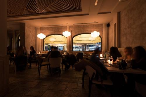 a group of people sitting at tables in a restaurant at Hotel Astoria in Tivat