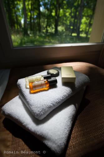 une pile de serviettes avec une bouteille de savon et un couteau dans l'établissement Le Domaine des Roches, Hotel & Spa, à Briare