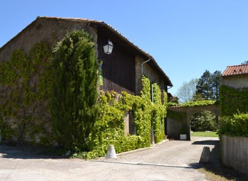 a building covered in ivy on a street at Gîtes du Hameau Baylesse in Saint-Jean-dʼAigues-Vives