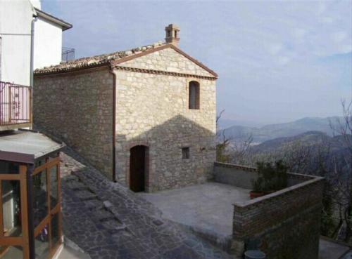 um pequeno edifício de tijolos com uma pequena porta no topo em B&B Casa Letizia em Montemitro