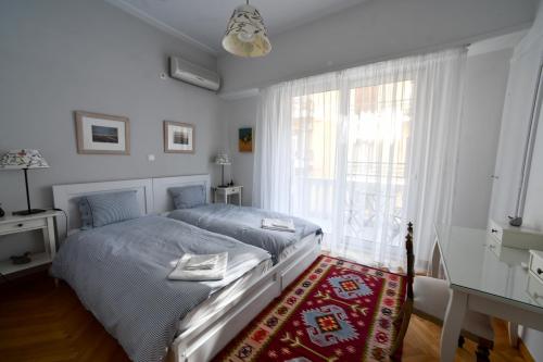 a bedroom with a bed and a large window at Athens Squared Apartments in Athens