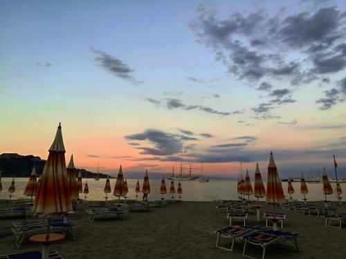 a group of umbrellas and chairs on a beach at Relax House in Giardini Naxos