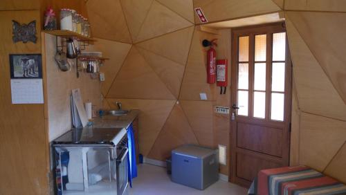 cocina con fregadero y puerta en una habitación en vale das cupulas, en Figueiró dos Vinhos