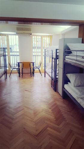 a room with bunk beds and a table and chairs at Sleep Inn Hostel in Bucharest