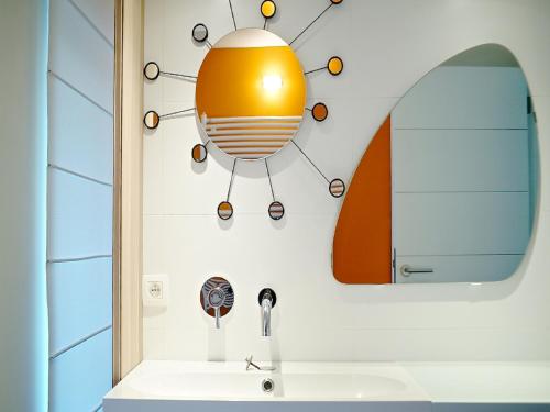 a bathroom with a light on the wall and a sink at Gîte Au26 côté jardin-côté cour in Liège