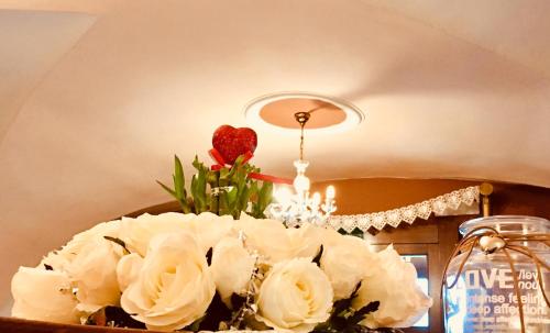 a bouquet of white roses on a table with a chandelier at Hotel Kriváň in Kysucké Nové Mesto