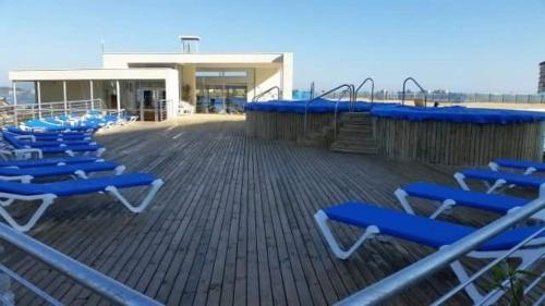 a group of blue lounge chairs on a deck at Laguna Bahía, Algarrobo in Algarrobo